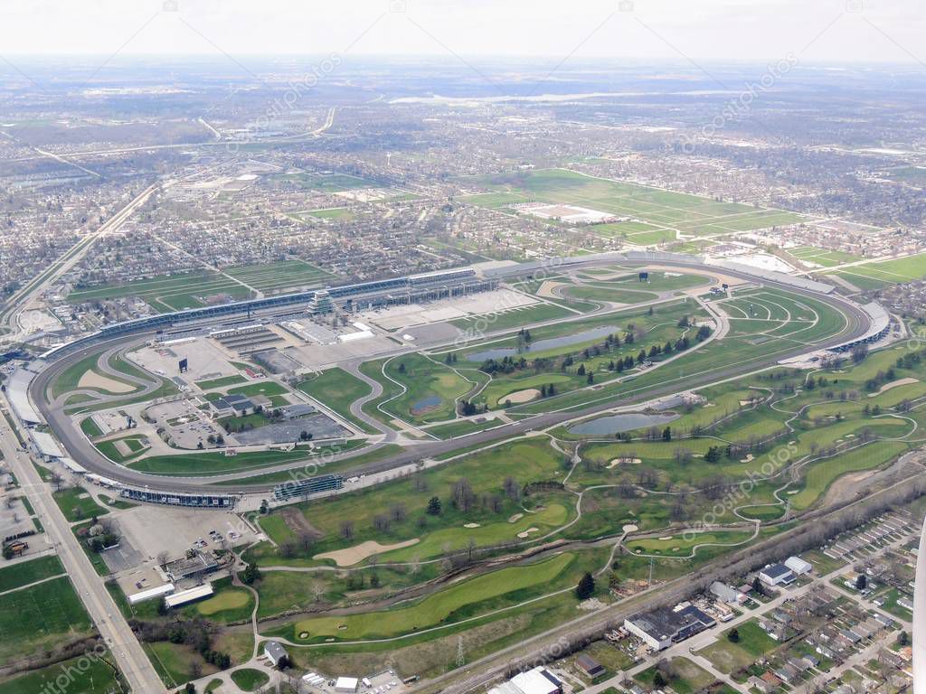 Aerial view of Indianapolis 500, an automobile race held annually at Indianapolis Motor Speedway in Speedway, Indiana through clouds. View from airplane.