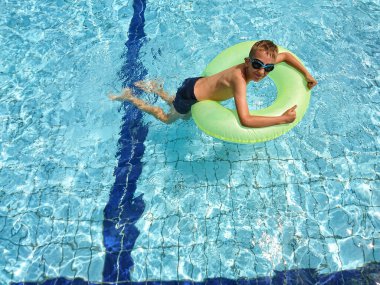 Havuzda can simidiyle yıkanan bir çocuk.