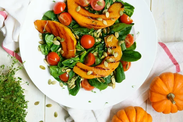 Sallad med grillad pumpa, spenat och tomater — Stockfoto