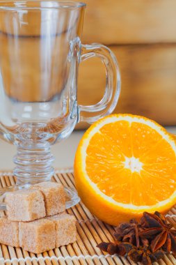 Mulled şarap için malzemeler: cam portakal tarçınlı yıldız anason Thatched şeker kahverengi ahşap stand arka plan üzerinde