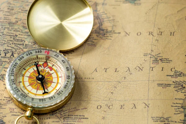 the old gold compass with cover on vintage map, macro background