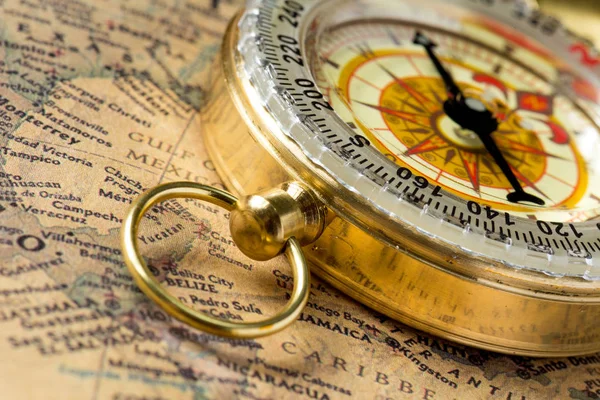 The old gold compass with cover on vintage map, macro background Royalty Free Stock Images