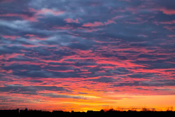 Kontrast Himmel blutrot Sonnenuntergang Silhouetten von städtischen Gebäuden schwarze Wolken Naturphänomen. Stockbild