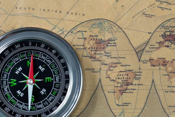 the Black compass on old vintage map, north and south America, macro background