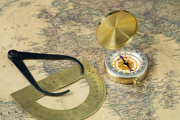 Ferramenta de medição velha bússola de ouro com tampa e transferidor no mapa vintage, fundo macro, bússolas — Fotografia de Stock