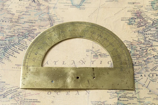 The old protractor on vintage map, macro background, compasses, Atlantic ocean Stock Picture