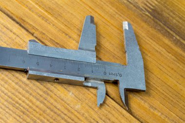yüksek hassasiyetli el ölçü araçları - vernier Çap pergeli ahşap arka plan kahverengi.