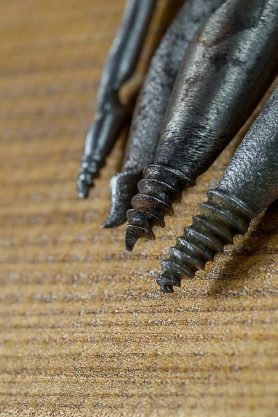 Los Varios gimlets distintos de los tamaños, las herramientas manuales para los agujeros de perforación en la madera. Fondo de madera contrachapada Macro Brown — Foto de Stock