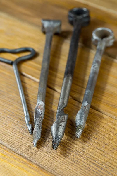 Los Varios gimlets diferentes tamaños viejos, las herramientas manuales para los agujeros de perforación en la madera. Contrachapado marrón fondo — Foto de Stock