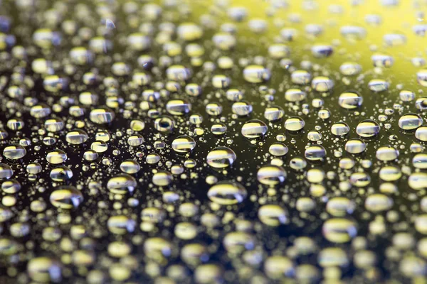 De abstracte zwart-gele achtergrond met kleurovergang water druppels op glas met reflectie, bockeh, macro — Stockfoto