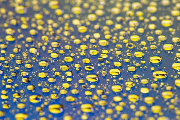 El fondo Abstracto azul-amarillo con el color degradado gotas de agua sobre el cristal con la reflexión, bockeh, macro —  Fotos de Stock