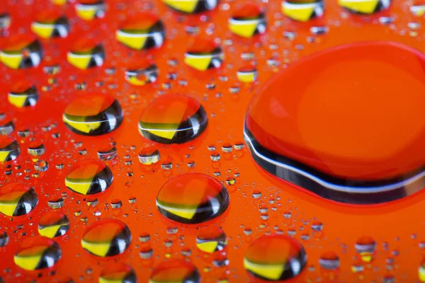 El fondo Abstracto anaranjado rojo con el color degradado las gotas de agua sobre el cristal con la reflexión, la gotita grande, macro — Foto de Stock