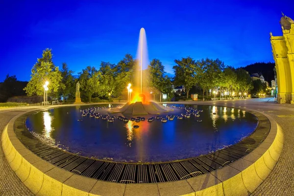 Columnata principal en la pequeña ciudad balneario bohemia oeste Marianske Lazne y fuente de canto por la noche - República Checa — Foto de Stock