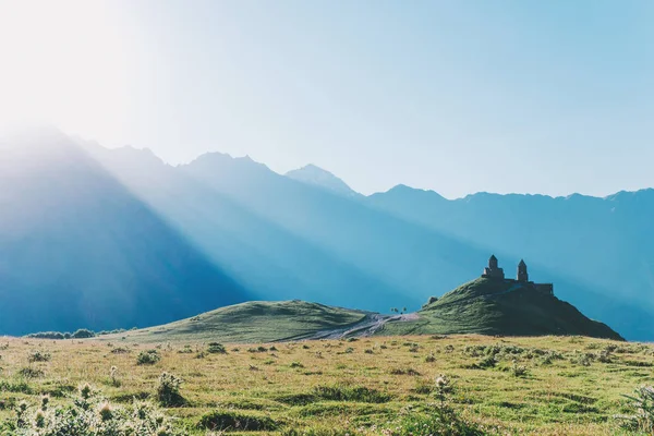 Троїцька церква в горах на тлі заходу сонця промені — стокове фото