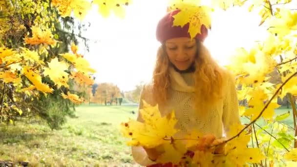 Ευτυχισμένος κορίτσι Καυκάσιος ποζάρει με maple φύλλα στον ήλιο — Αρχείο Βίντεο