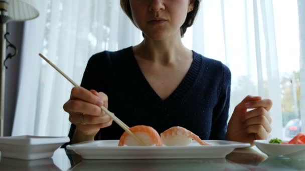 Νεαρό κορίτσι Καυκάσιος τρώει σούσι σε ιαπωνικό εστιατόριο — Αρχείο Βίντεο