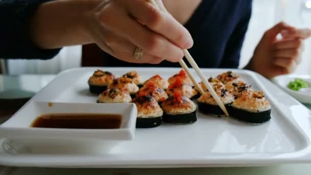 일본 레스토랑에서 초밥을 먹는 젊은 백인 여자 — 비디오
