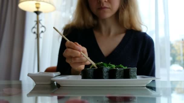 Jovem caucasiano menina comer sushi em um japonês restaurante — Vídeo de Stock