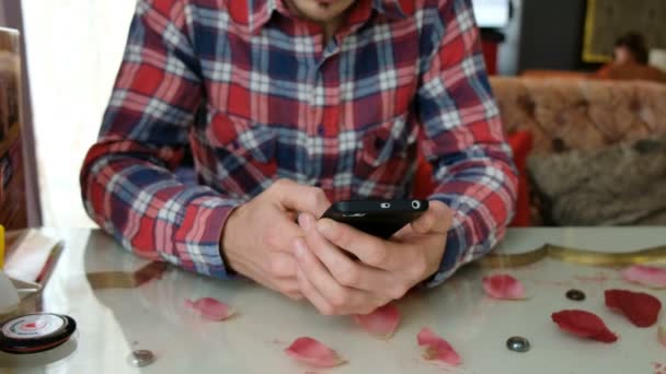 Молодой кавказский мужчина со смартфоном в кафе — стоковое видео