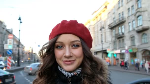 Красивая привлекательная девушка смотрит в камеру и позирует крупным планом в городе на улице — стоковое видео