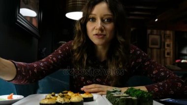 Güzel beyaz bir Japon restoranı, ve ilginç bir şey suşi yemek bir kadın arkadaşı ters söyler