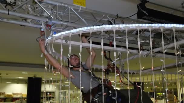 Arrampicatore industriale allestisce decorazioni natalizie nel centro commerciale — Video Stock