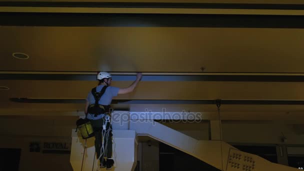 Industrial climber mounts Christmas decorations in the unsupported space in the shopping center — Stock Video