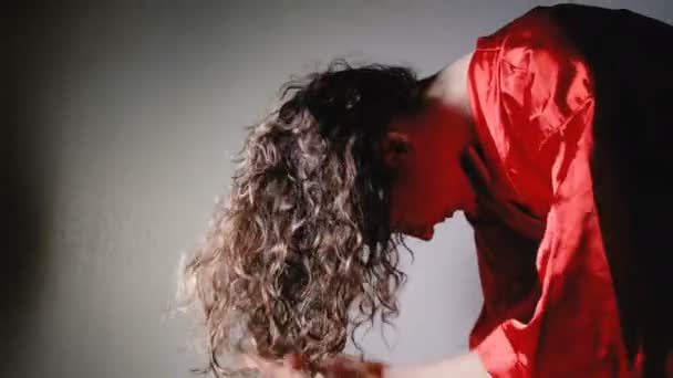 Молода жінка з коричневим волоссям сушить волосся нахил голови з електричною сушаркою в домашніх умовах, 4K . — стокове відео