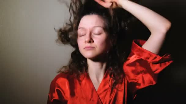 Una joven levanta la cabeza y se seca el pelo en casa, 4K . — Vídeo de stock