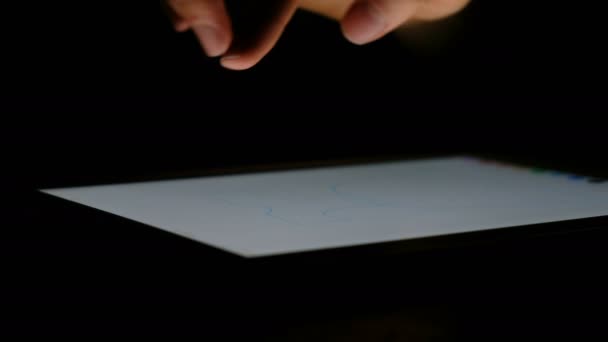 Рука рисует на планшетных узоров в темноте крупным планом, 4k . — стоковое видео