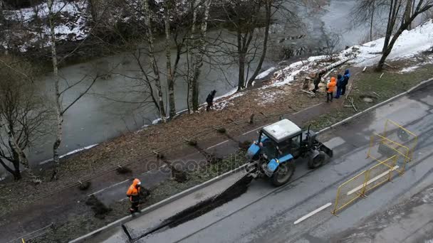 Straßenarbeiten, ein Bagger schneidet den Asphalt und Arbeiter kümmern sich um den Prozess, 4k. — Stockvideo