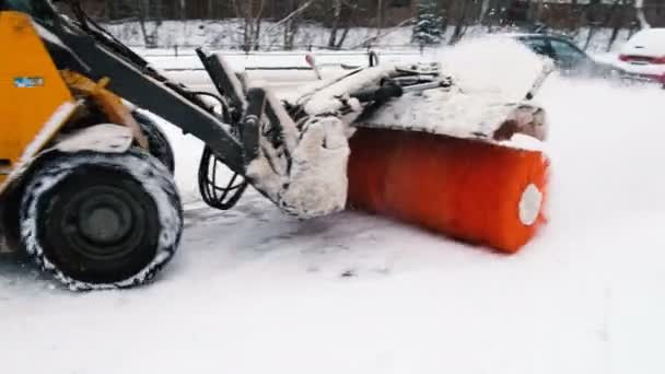 Soplador de nieve con el cepillo barredora limpia la nieve en el camino, 4K . — Vídeo de stock