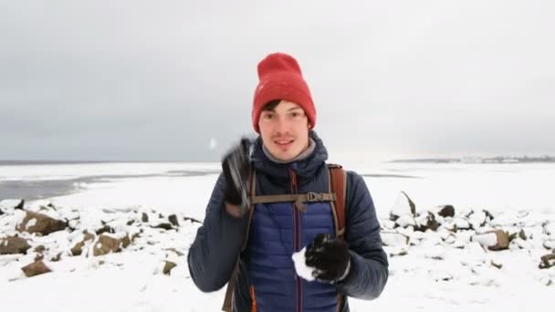 Un hombre hace una bola de nieve y quiere correr hacia la cámara, 4K . — Vídeos de Stock