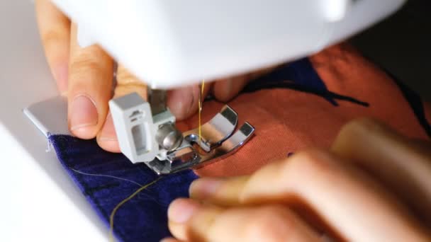 Жінка шиє на швейній машинці, вимотуючи лінію і закінчуючи шиттям, 4k . — стокове відео