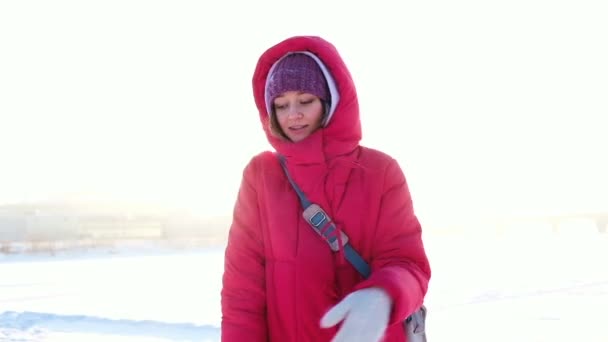 Девушка в яркой куртке танцует на закате зимой, замедленная съемка . — стоковое видео