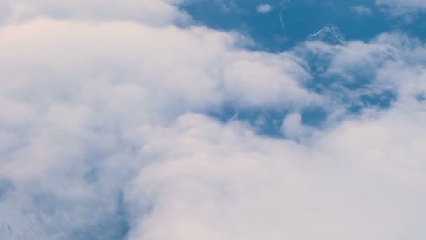 Pohled z letadla na zasněžené hory a mraky, 4k. — Stock video