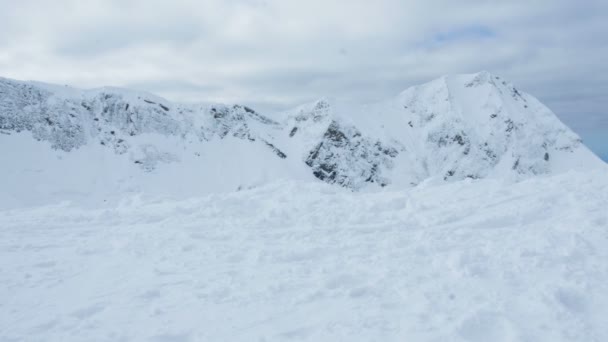 Un skieur en costume lumineux arrive au sommet de la montagne, 4k . — Video