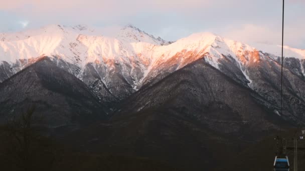 Funicular trabalha contra um belo pôr do sol nas montanhas, 4k . — Vídeo de Stock