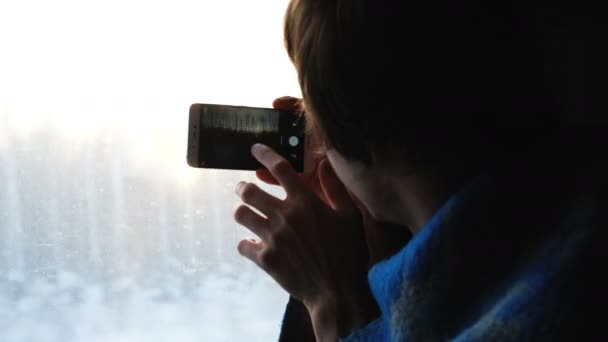 Man in een geruite foto's van de natuur op de telefoon zit in een trein, 4k. — Stockvideo