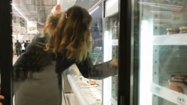 Güzel kız mağaza buzdolabında mal seçer