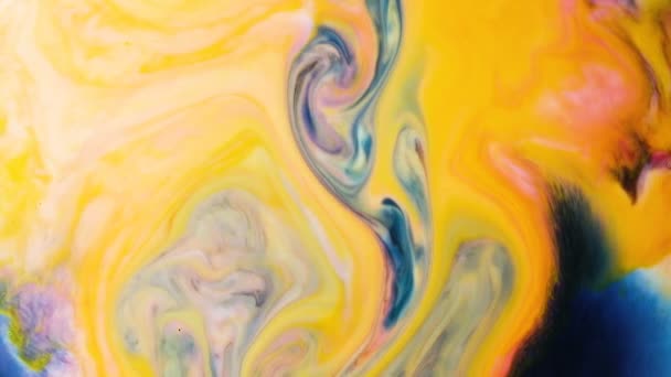 Contexte psychédélique abstrait. L'encre bleue est versée dans la peinture jaune dans le lait au ralenti 