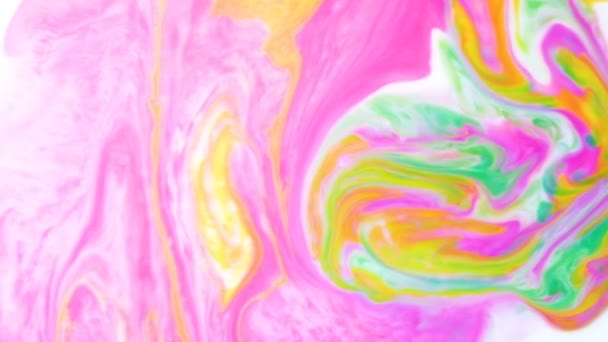 Абстрактний психоделічний фон. Жовте чорнило змішане з рожевими та зеленими чорнилами у повільному русі молока — стокове відео