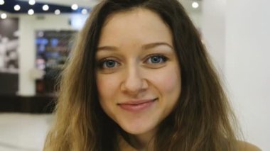 Bir alışveriş merkezinde güzel bir gülümseyen kız yakın çekim portresi