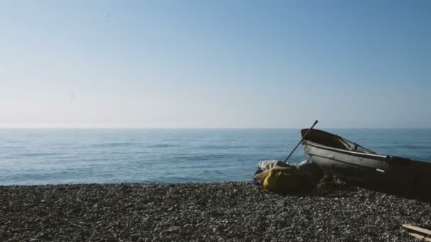 Човен стоїть на березі моря в чисту погоду — стокове відео