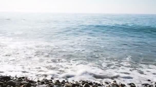 Golven slaan op kiezels, azuurblauwe zee op een zonnige dag — Stockvideo