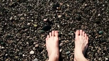 Ağır çekim deniz dalgalarının erkeksi çıplak bacaklar tarafından yıkanmış