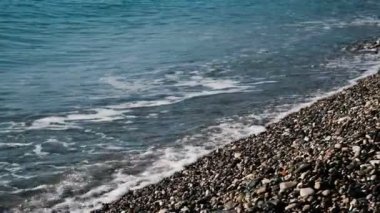 Deniz dalgaları dökmek çakıl plajı içine yakın çekim