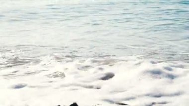 Dalgalar deniz kıyısında ağır çekim yakın çekim güneşli bir günde Parlatıcı