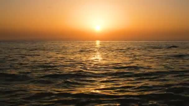 Calma onde del mare sullo sfondo del tramonto arancione — Video Stock