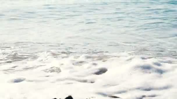 Meereswellen leuchten an einem sonnigen Tag am Ufer in Zeitlupe Nahaufnahme — Stockvideo
